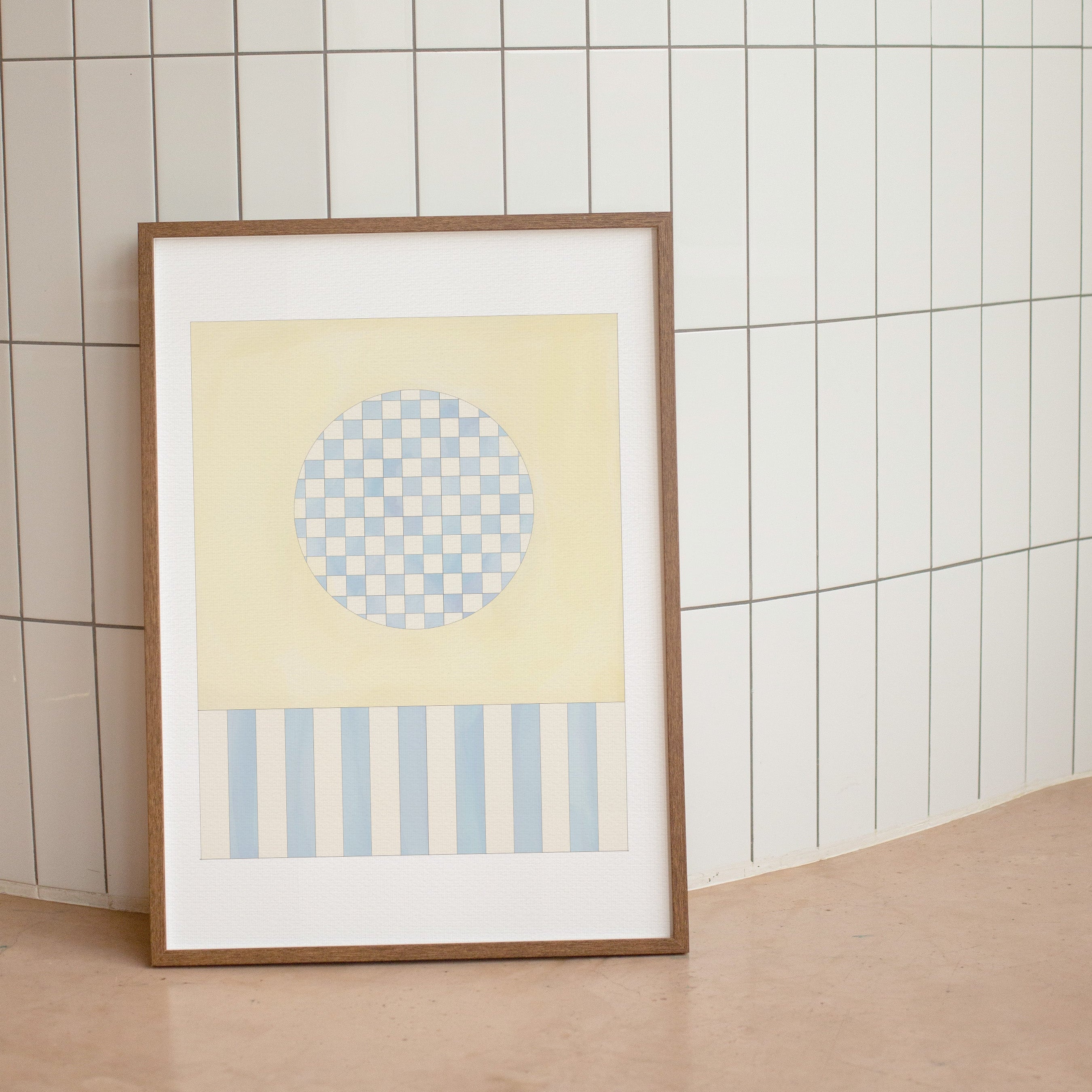 Framed abstract art print with geometric patterns on a tiled wall.