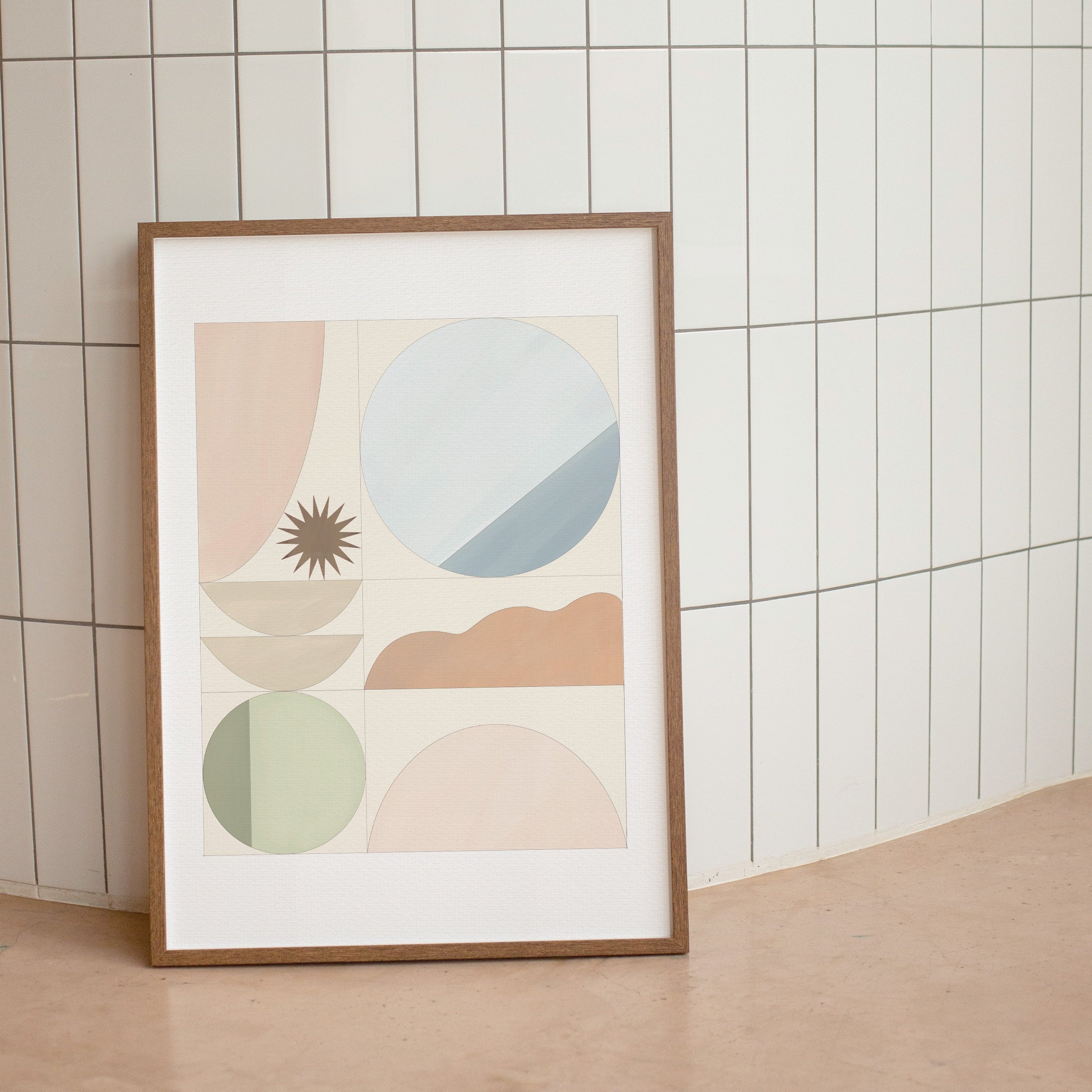 Framed abstract art print with geometric shapes on a tiled wall.