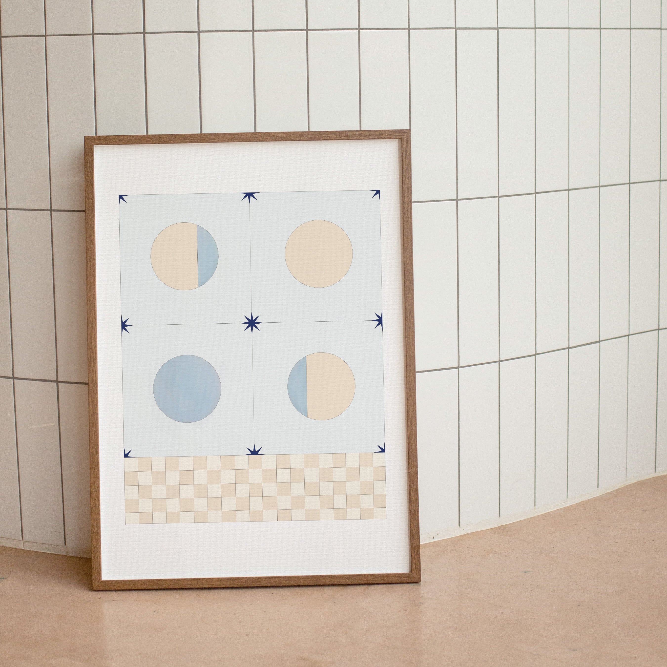 Framed abstract art print with geometric shapes on a tiled wall.